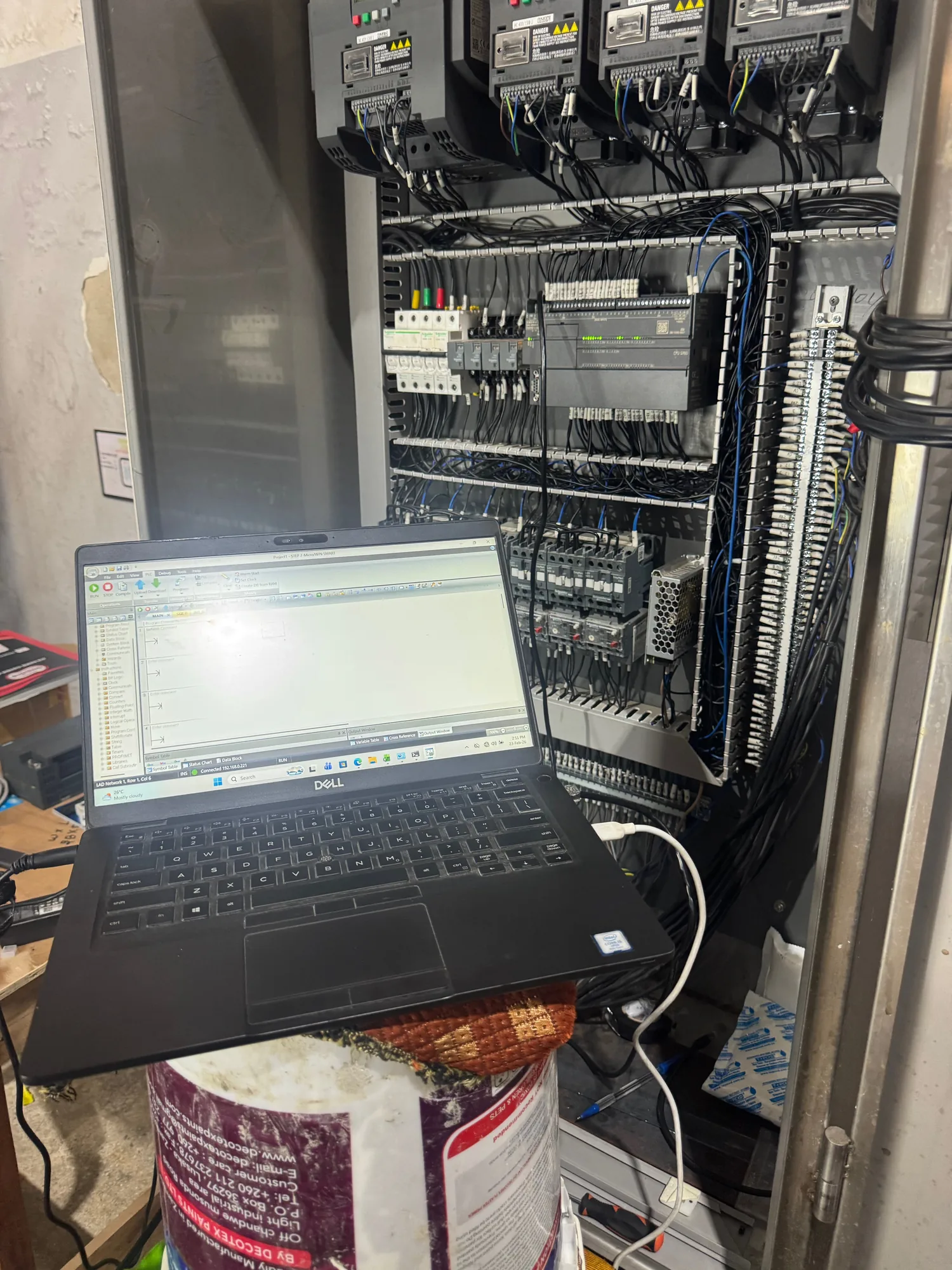 PLC commissioning on site with a laptop connected to the control panel