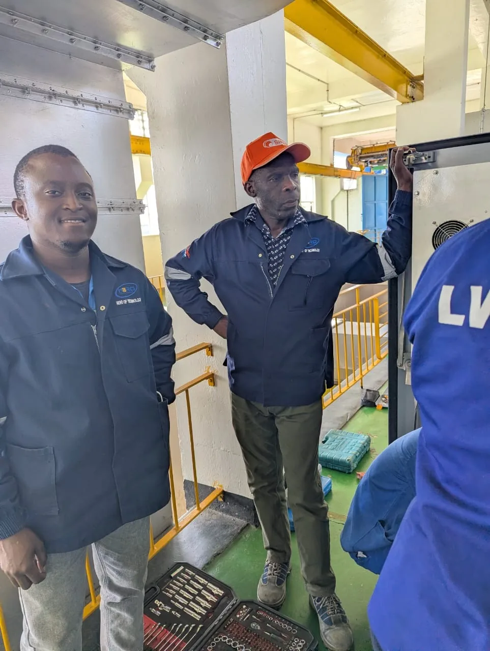 HCS technician with utility staff in a pump-station plant room